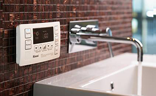 Digital gas meter displaying usage details in a kitchen setting.