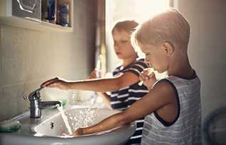 Children washing at the water tab at home